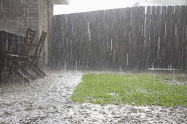 Regen prasselt auf die Terasse und den Rasen und versickert nicht schnell genug